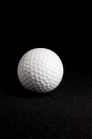 bola de golfe em fundo preto foto
