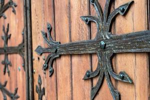 padrão de porta forjado, decorativo. antiga entrada vintage, enorme porta de madeira pesada da igreja ou catedral. foto