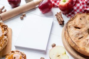 maquete de capa de livro de culinária em branco com torta de maçã, torta de carne e frutas da estação foto