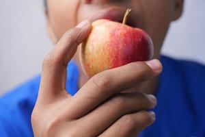 menino criança comendo maçã close-up foto