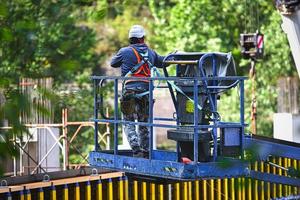 homem trabalhando em elevadores de carga em um canteiro de obras foto