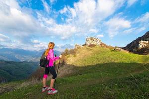 mulher solteira nas montanhas olha para o panorama foto