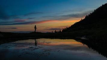 peregrinação solitária ao pôr do sol perto de um lago com cores de conto de fadas foto