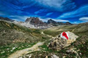 marca vermelha na rocha para trilha de montanha foto