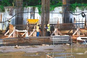 trabalhadores do canteiro de obras preparam armadura de ferro para concreto foto