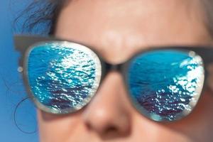 reflexo do mar nos óculos da menina foto