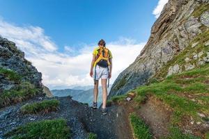 menina sozinha ultrapassa a passagem da montanha foto