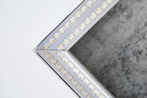 luz led de tira com perfil quadrado de alumínio no teto tenso, close-up. conceito de renovação em casa foto