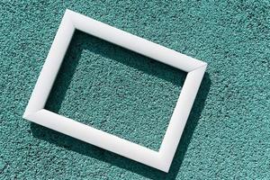 uma moldura branca vazia em um fundo texturizado turquesa, com um espaço de cópia. conceito mínimo foto