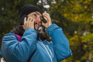 uma turista está falando ao telefone na floresta, um turista se perdeu em uma floresta escura. um pedido de ajuda. foto