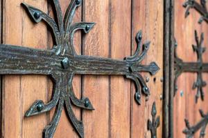 padrão de porta forjado, decorativo. antiga entrada vintage, enorme porta de madeira pesada da igreja ou catedral. foto