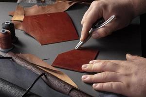 o processo de fabricação de artigos de couro. as mãos do mestre trabalham com um produto de couro. foto