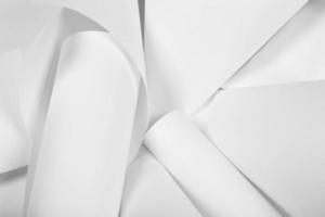 folhas brancas de papel de escritório são torcidas e espalhadas. fundo abstrato de papel branco. foto