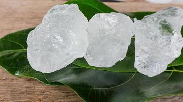 cubos de alume cristalino ou alume de potássio em folhas verdes conceito de substância química composta para spa de beleza e tratamento industrial de axilas foto