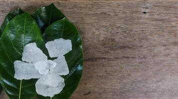 cubos de alume cristalino ou alume de potássio em folhas verdes conceito de substância química composta para spa de beleza e tratamento industrial de axilas foto