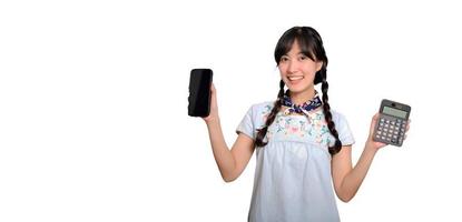 retrato da bela jovem mulher asiática em vestido jeans segurando calculadora e smartphone em fundo branco. conceito on-line de compras de negócios. foto
