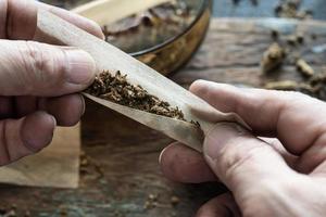 fumante de cannabis rolando maconha cannabis joint.drugs conceito narcótico. foto