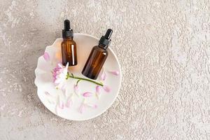 dois frascos de cosméticos com uma pipeta com um produto orgânico natural para o cuidado da pele facial antienvelhecimento. elevação. vista do topo. um espaço de cópia. foto