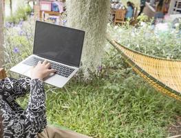 a mão da garota imprime o texto no teclado do laptop. conceito de um freelancer. foto