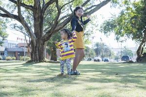 família asiática se divertindo no jardim mãe e filha se divertindo juntos. foto