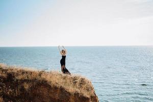 modelo de menina alta em um vestido preto nas colinas de montanha foto