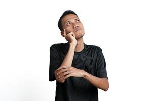 homem asiático vestindo camiseta preta de treinamento, pensando em gestos ou tendo uma ideia. isolado por fundo branco foto
