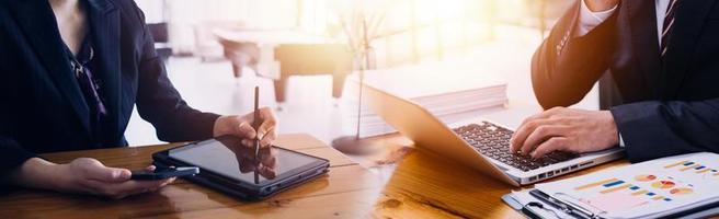 tiro de duas empresária trabalhando juntos em tablet digital. executivos femininos criativos reunidos em um escritório usando o tablet pc e sorrindo. foto