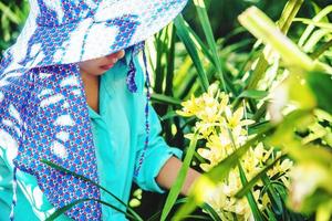 a jovem trabalhadora está cuidando da flor da orquídea no jardim. amarelo da orquídea cymbidium. foto