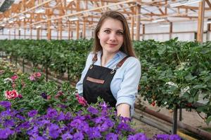 jovem bela mulher de negócios em estufa de flores foto