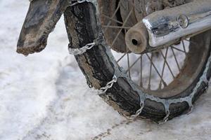 close-up de uma moto com correntes de neve foto