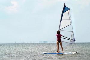 silhueta de uma menina windsurfista foto