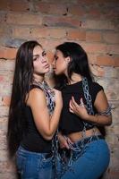 duas morenas sensuais em jeans e camisetas pretas foto