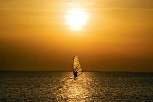 windsurfista sobre o pôr do sol foto