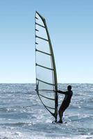 silhueta de um windsurfista em um mar foto