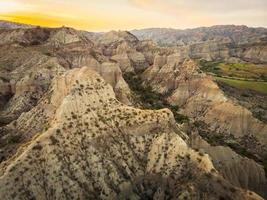 panorama surreal dramático da paisagem da terra deserta com belas formações de penhasco e fundo do sol dourado no parque nacional de vashlovani. destino de viagem na Geórgia. foto