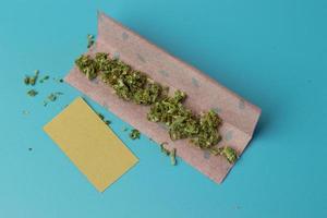 papel comum para rolo de cannabis na vista superior de fundo azul, acessório para fumar maconha foto