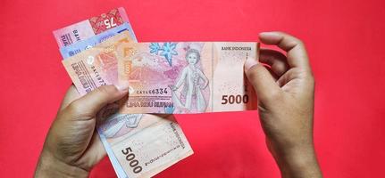 homem segurando notas da Indonésia, a última edição. moeda da indonésia foto