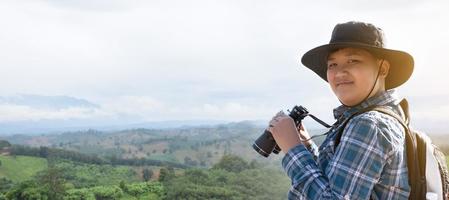 meninos asiáticos usando binóculos para observar pássaros em árvores e pescar no rio no parque nacional local durante o acampamento de verão, ideia para aprender criaturas e animais selvagens e insetos fora da sala de aula. foto