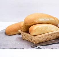 pães de trigo branco em uma cesta de vime foto