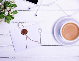 xícara de café e um envelope de papel selado foto