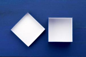 abra a caixa de papelão quadrada vazia para presentes em um fundo azul de madeira foto