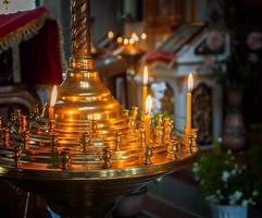 queimando velas de cera em um suporte na igreja foto