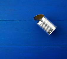 abra grande lata de metal em um fundo azul de madeira de placas paralelas foto