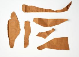pedaços marrons rasgados de papel pergaminho em um fundo branco foto