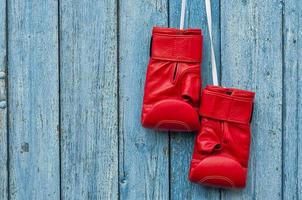 par de luvas de boxe vermelhas penduradas em um prego foto