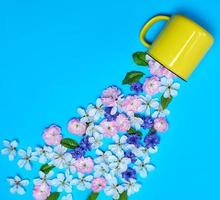 caneca de cerâmica amarela e botões de flores foto