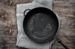 frigideira preta vazia de ferro fundido em um guardanapo têxtil foto