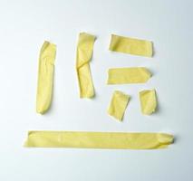 conjunto de vários pedaços de fita adesiva amarela sobre um fundo branco foto