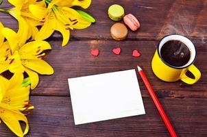 cartão vazio e uma xícara de café em uma caneca amarela foto