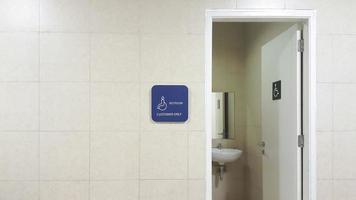 entrada do banheiro para deficientes. banheiro ou armário de água ou sinal de wc para banheiro acessível para cadeira de rodas deficiente. porta aberta. foto